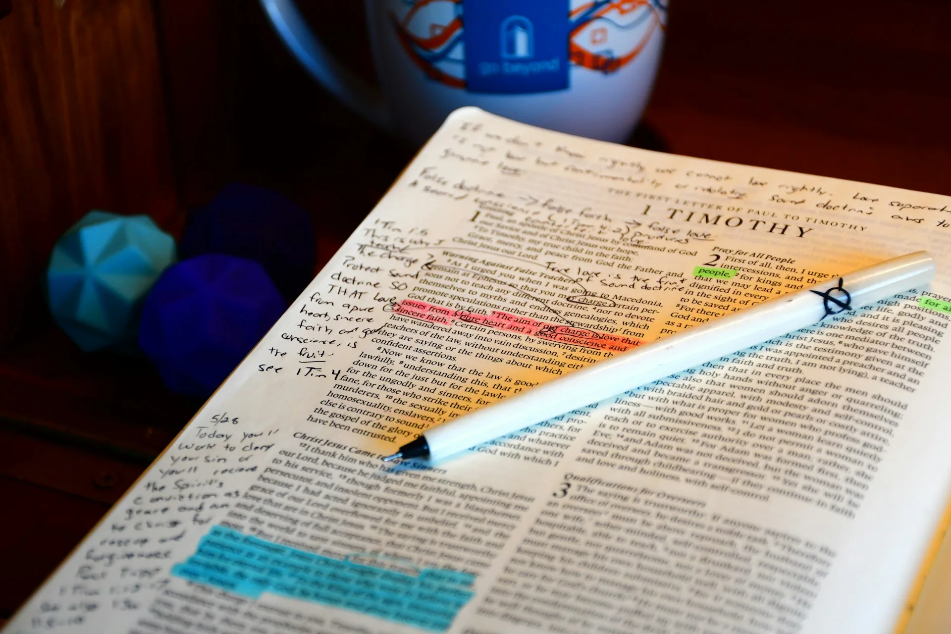 An open Bible with handwritten notes and a pen